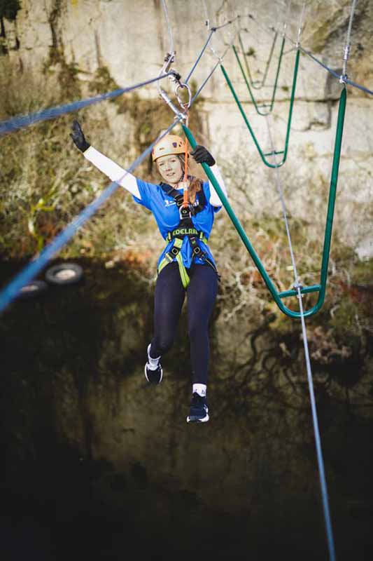 Adventure Day Out at Via Ferrata Cornwall - girl swinging on the high wire bridge