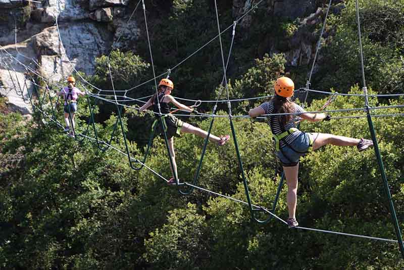 Teens on the high wire bridge at Via Ferrata Cornwall