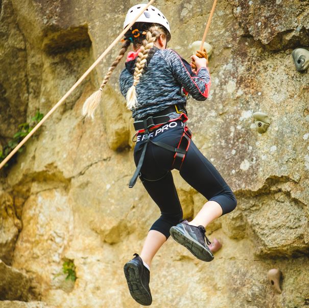 Girl climbing up quarry wall at Adventure Holiday Club