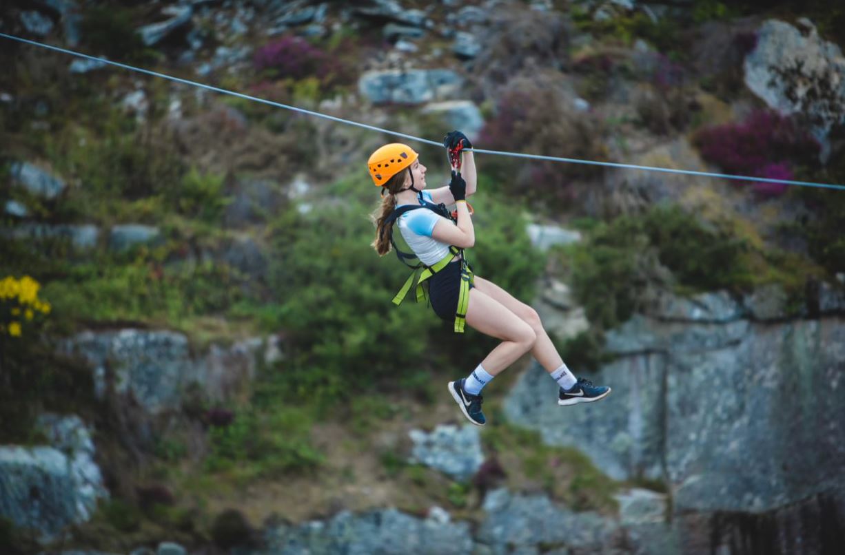 Girl flying through the air on Zip wire at Via Ferrata Cornwall