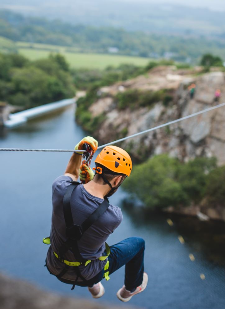 Man launching off the cliff on the Via Ferrata Zip Wire adventure
