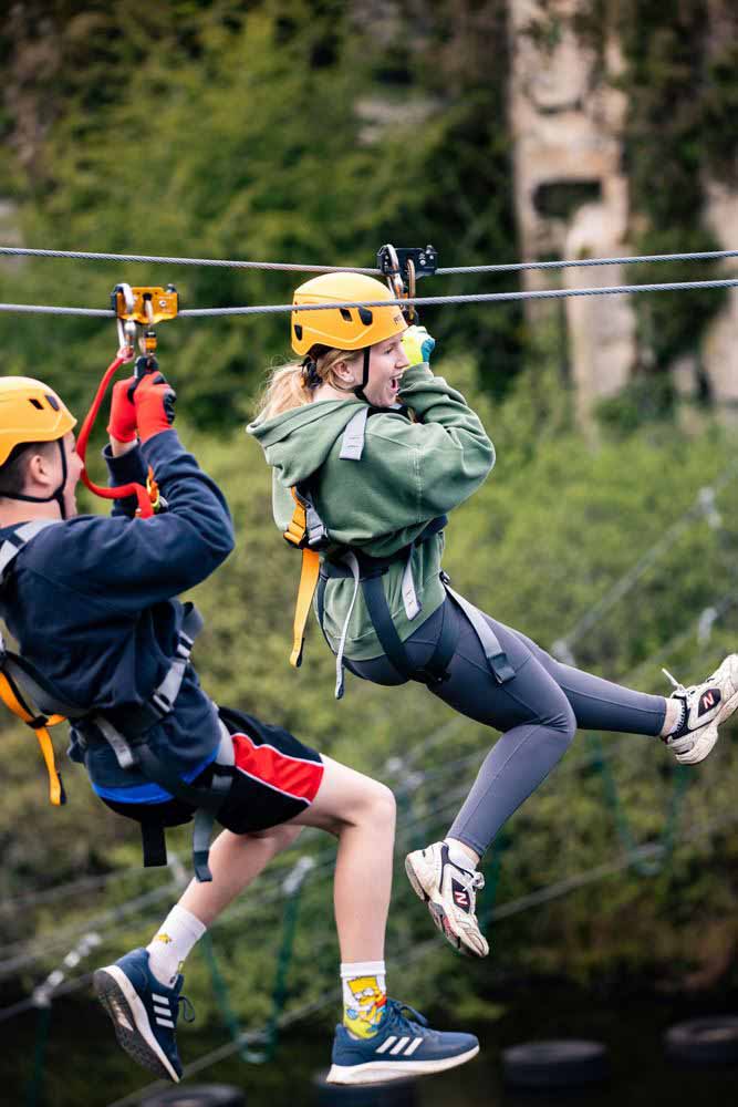 Participants flying across the adventure quarry on the Zip Wire Safari in Cornwall